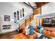Open-concept living room featuring exposed wood beams, an open staircase, and comfortable seating at 3033 Blake St # 109, Denver, CO 80205