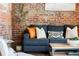 Close-up of a cozy living room with a stylish sofa, rustic coffee table, and exposed brick at 3033 Blake St # 109, Denver, CO 80205