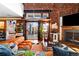 Living room boasts exposed brick, a fireplace, sliding glass doors, and a comfortable orange velvet sofa at 3033 Blake St # 109, Denver, CO 80205