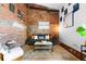 Modern living room with an exposed brick wall, neutral decor, and hardwood flooring at 3033 Blake St # 109, Denver, CO 80205