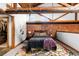 Bedroom with exposed brick accent wall, wood beams, and stylish decor at 3033 Blake St # 109, Denver, CO 80205