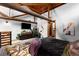 Bedroom featuring exposed wood beams and a modern dresser with mounted television at 3033 Blake St # 109, Denver, CO 80205