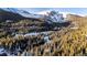 Aerial view of a snowy mountain community with evergreen trees at 381 Lake Rd, Idaho Springs, CO 80452