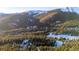 Aerial view of a snowy mountainside community with evergreen trees at 381 Lake Rd, Idaho Springs, CO 80452