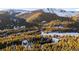 Aerial view of a snowy mountain community nestled among evergreen trees at 381 Lake Rd, Idaho Springs, CO 80452