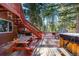 Deck with picnic table, hot tub, stairs, and wooded views at 381 Lake Rd, Idaho Springs, CO 80452