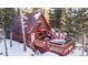 A-frame cabin with deck, hot tub, and snowy mountain backdrop at 381 Lake Rd, Idaho Springs, CO 80452