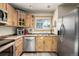 Kitchen boasts wood cabinets, stainless steel appliances, and a window overlooking the backyard at 381 Lake Rd, Idaho Springs, CO 80452