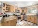 L-shaped kitchen with wood cabinets, stainless steel appliances, and tile floor at 381 Lake Rd, Idaho Springs, CO 80452