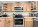 View of kitchen range, oven and microwave with wood cabinets at 381 Lake Rd, Idaho Springs, CO 80452