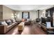 Living room with wood floors, leather couches, and a wood-burning stove at 381 Lake Rd, Idaho Springs, CO 80452