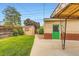Well-maintained backyard featuring a manicured lawn, small storage shed, and covered patio with a green door at 6930 Warren Dr, Denver, CO 80221