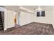 Finished basement area with neutral carpeting and white walls at 6930 Warren Dr, Denver, CO 80221