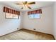 This bedroom features two windows with valances and a ceiling fan at 6930 Warren Dr, Denver, CO 80221
