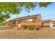 Quaint brick home with low-maintenance landscaping, featuring gravel and green shrubbery near the house at 6930 Warren Dr, Denver, CO 80221