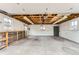 Spacious garage featuring unfinished ceiling, concrete floor, large windows, storage shelves, and metal cabinet at 6930 Warren Dr, Denver, CO 80221