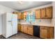 Well-lit kitchen featuring wood cabinets, ample counter space, and modern appliances, including a refrigerator at 6930 Warren Dr, Denver, CO 80221