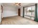 Comfortable living room features neutral carpet, a ceiling fan, and natural light through a large window at 6930 Warren Dr, Denver, CO 80221