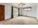 Spacious living room with hardwood door, two windows and neutral carpet, providing ample natural light at 6930 Warren Dr, Denver, CO 80221