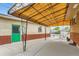 Relaxing outdoor patio with a yellow awning, decorative wrought iron posts, and a bright green entry door at 6930 Warren Dr, Denver, CO 80221