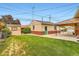 A backyard featuring a storage shed and covered patio, and a manicured green lawn at 6930 Warren Dr, Denver, CO 80221
