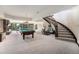 Open basement layout with pool table, stone fireplace and access to the upper level at 8337 Greenwood Dr, Niwot, CO 80503