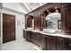 A bathroom with white marble countertops and dark wood cabinets featuring dual vessel sinks and skylights above at 8337 Greenwood Dr, Niwot, CO 80503