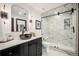 Modern bathroom with black vanity and large shower with marble-style tile and glass door at 8337 Greenwood Dr, Niwot, CO 80503