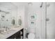 Bright bathroom with white tile shower and dark wood vanity with white counter and rectangular mirror at 8337 Greenwood Dr, Niwot, CO 80503