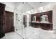 Luxury bathroom featuring a frameless glass shower and dual vanities with vessel sinks and dark wood cabinetry at 8337 Greenwood Dr, Niwot, CO 80503
