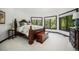 Bright bedroom with large windows showcasing serene greenery, complemented by a dark wood bed frame and furnishings at 8337 Greenwood Dr, Niwot, CO 80503