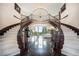 Grand foyer features a double staircase, marble floors, and a chandelier, showcasing the home's luxurious design at 8337 Greenwood Dr, Niwot, CO 80503