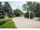 Landscaped front yard with a circular driveway leading to the beautiful brick home and mature trees at 8337 Greenwood Dr, Niwot, CO 80503