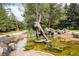 Serene water feature with statue, rocks and mature trees, enhancing the landscape at 8337 Greenwood Dr, Niwot, CO 80503
