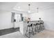 Basement bar area with gray carpet and tile flooring, a mini fridge, and wooden bar stools at 8107 Arapahoe Peak St, Littleton, CO 80125