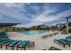 Community pool featuring lounge chairs, tables, umbrellas and neighborhood homes in the background at 8107 Arapahoe Peak St, Littleton, CO 80125