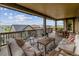 Covered outdoor deck area with comfortable seating and dining, showcasing beautiful views of the community at 8107 Arapahoe Peak St, Littleton, CO 80125