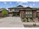 Two-story house with stone and siding exterior, two-car garage, and landscaping at 8107 Arapahoe Peak St, Littleton, CO 80125