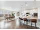 Open-concept kitchen with a large island, white cabinets, and dining area at 8107 Arapahoe Peak St, Littleton, CO 80125