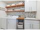 Bright laundry room with patterned wallpaper, wood shelving, and ample storage at 8107 Arapahoe Peak St, Littleton, CO 80125