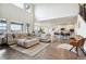 Spacious living room with hardwood floors, sectional sofa, and large windows at 8107 Arapahoe Peak St, Littleton, CO 80125