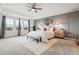 Large main bedroom featuring tray ceilings, many windows, and stylish decor at 8107 Arapahoe Peak St, Littleton, CO 80125