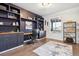 Home office with built-in shelves, desk, hardwood floors, and a large window providing natural light at 8107 Arapahoe Peak St, Littleton, CO 80125