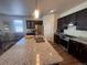 Gourmet kitchen with granite countertops, stainless steel appliances, dark wood cabinetry and large center island at 5741 Echo Park Cir, Castle Rock, CO 80104