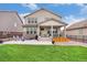 Expansive backyard features a stone patio, green lawn, and a charming two-story home at 8078 S Yantley Ct, Aurora, CO 80016