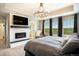 Comfortable bedroom with an electric fireplace, TV, and large windows offering ample natural light at 8078 S Yantley Ct, Aurora, CO 80016