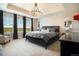Bright bedroom featuring a tray ceiling, plush carpet, and an abundance of natural light through large windows at 8078 S Yantley Ct, Aurora, CO 80016