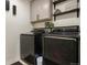 Modern laundry room with dark appliances, storage cabinets, and decorative shelving above at 8078 S Yantley Ct, Aurora, CO 80016