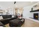 Open-concept living room with modern furniture, a cozy fireplace, and seamless flow into the kitchen area at 8078 S Yantley Ct, Aurora, CO 80016