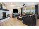 Inviting living room featuring a cozy fireplace, hardwood floors, and large windows with natural light at 8078 S Yantley Ct, Aurora, CO 80016